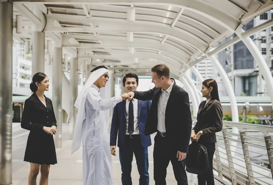 Foreigner business owners shaking hands with an Emirati sheikh over golden visa approval